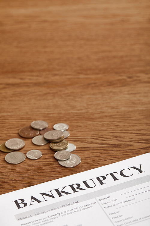 bankruptcy form and coins on brown wooden table