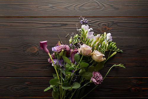 top view of violet and purple floral bouquet on wooden table