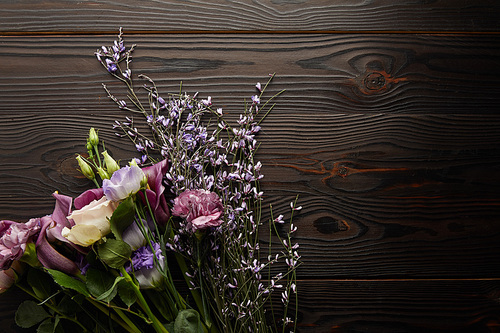 top view of violet and purple floral bouquet on wooden table