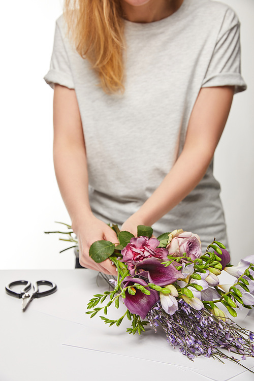 cropped view of florist making violet bouquet isolated on white