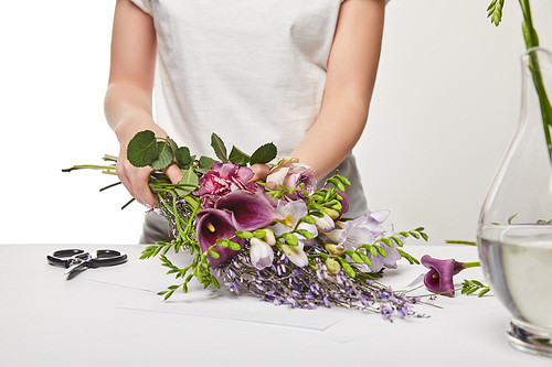 cropped view of florist making violet bouquet isolated on white