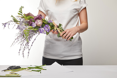 cropped view of florist holding violet bouquet isolated on white