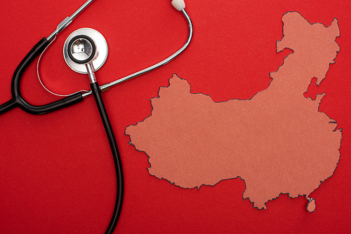 Top view of layout of china map with stethoscope on red background