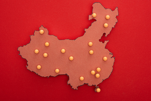 Top view of map of china with yellow push pins on red background