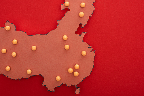 Top view of map of china with yellow push pins on red background