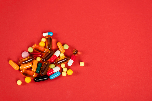 colorful pills on red with copy space
