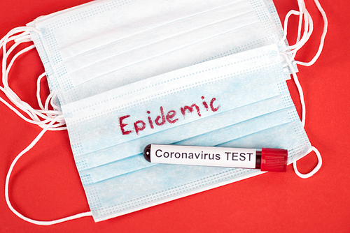 top view of sample with coronavirus test near protective medical masks with epidemic lettering on red