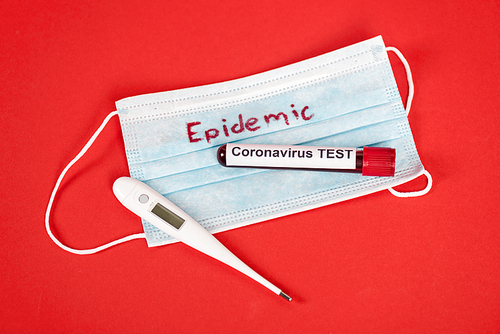 top view of sample with coronavirus test near protective medical mask with epidemic lettering and digital thermometer on red