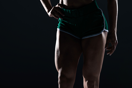 cropped view of female bodybuilder with muscular legs, isolated on black