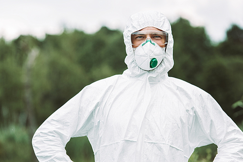 selective focus of smiling male scientist in protective mask and suit  outdoors