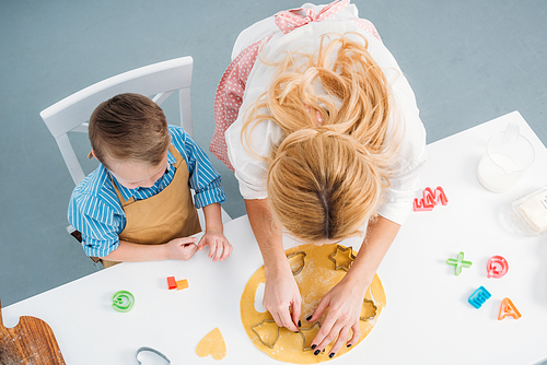 High angle view of son and mother using cooking molds