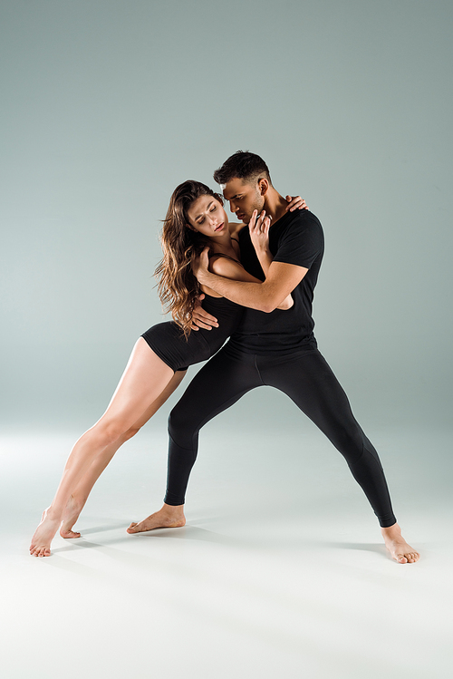dancers with closed eyes dancing contemporary on grey background