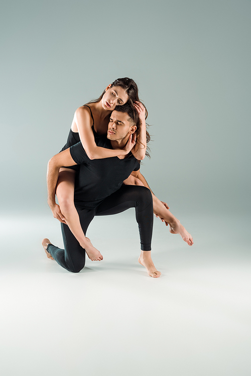 dancers with closed eyes dancing contemporary on grey background