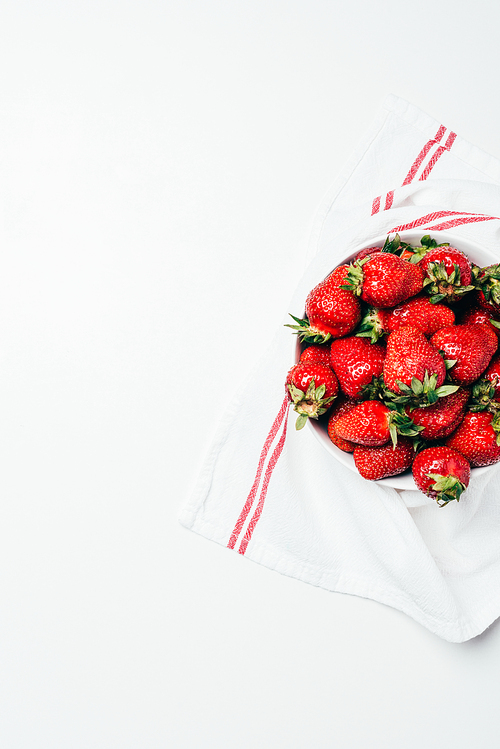 tp view of fresh ripe red sweet strawberries in bowl with towel on white