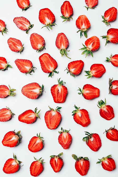 pattern with delicious fresh healthy halved strawberries on white