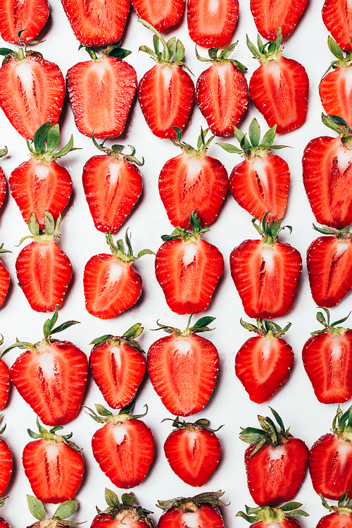 top view of seamless pattern made of ripe fresh sliced strawberries on white