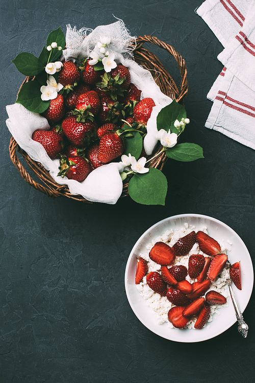 top view of healthy cottage cheese and ripe fresh strawberries on black