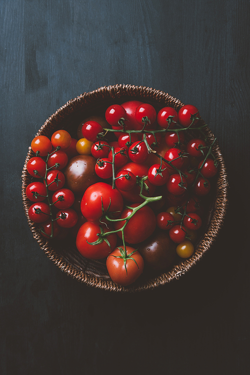 top view of red cherry tomatoes in wicker bowl