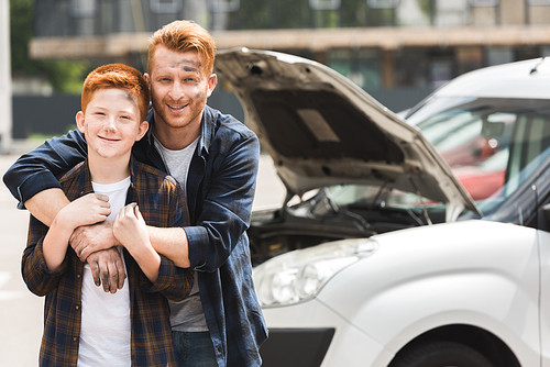 happy father hugging son after repairing car