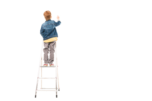 back view of schoolboy standing on ladder and writing isolated on white