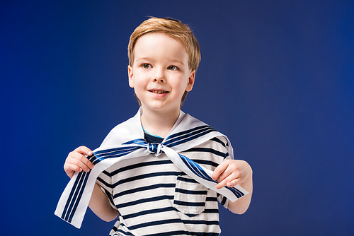 adorable boy in sailor costume with striped t-shirt, isolated on blue