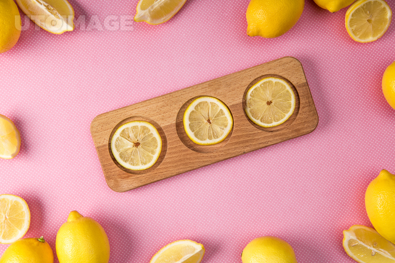 유토이미지 | top view of fresh lemon slices on wooden board with lemons around on pink background