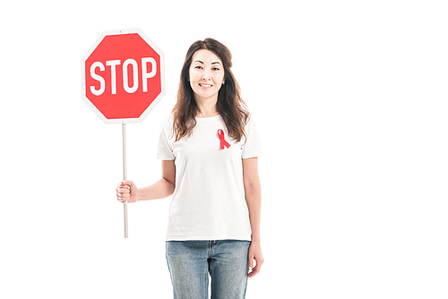 smiling adult asian woman with aids awareness red ribbon on t-shirt holding stop road sign isolated on white