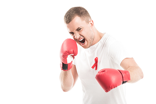 angry handsome man in blank white t-shirt with aids awareness red ribbon and boxing gloves isolated on white, fighting aids concept