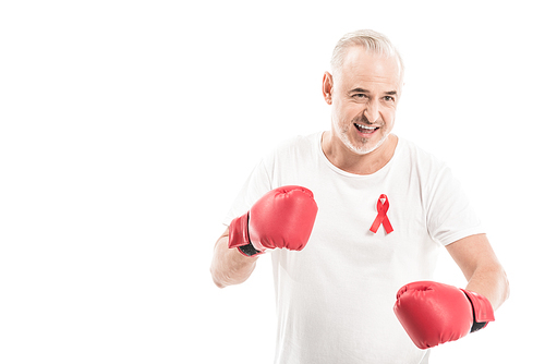 emotional mature man in blank white t-shirt with aids awareness red ribbon and boxing gloves isolated on white, fighting aids concept