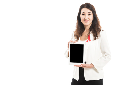 smiling asian businesswoman with aids awareness red ribbon on jacket holding tablet and  isolated on white