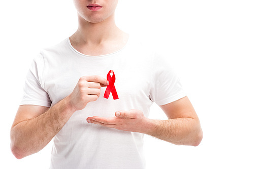 cropped image of man showing red ribbon on shirt isolated on white, world aids day concept
