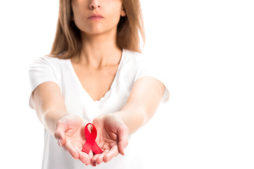 cropped image of woman holding red ribbon in hands isolated on white, world aids day concept