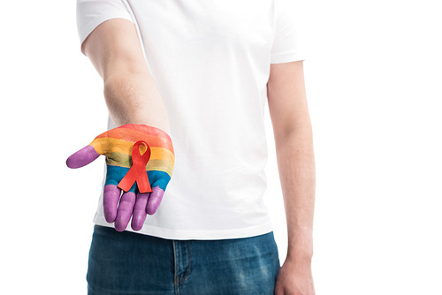 cropped image of homosexual man holding red ribbon on hand painted in rainbow isolated on white, world aids day concept