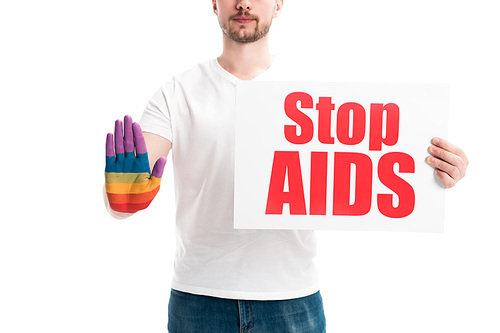 cropped image of man showing stop sign with hand painted in rainbow and holding card with stop aids text isolated on white