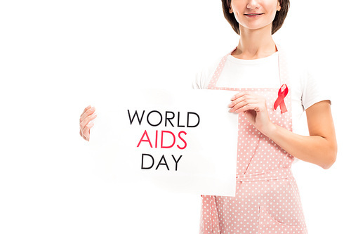 cropped image of housewife in pink apron and red ribbon showing world aids day card isolated on white