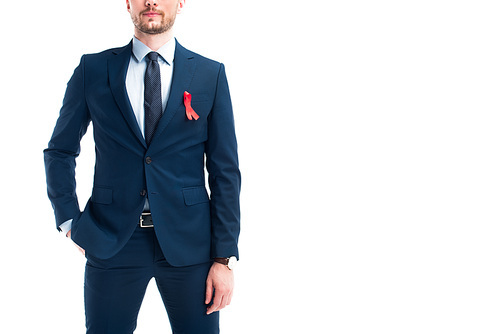 cropped image of businessman standing with red ribbon on suit isolated on white, world aids day concept