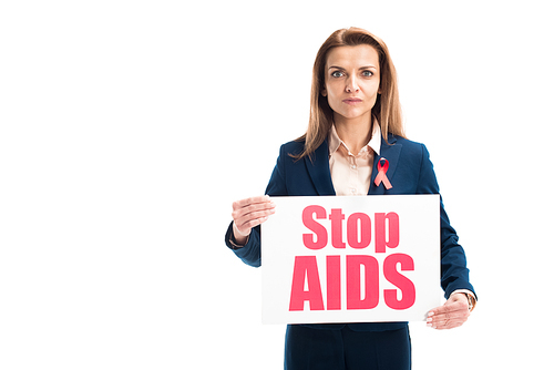 attractive businesswoman with red ribbon on suit showing card with stop aids text isolated on white