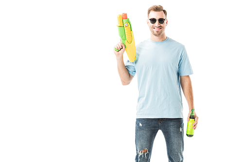 Smiling man standing in sunglasses with bottle and water gun isolated on white