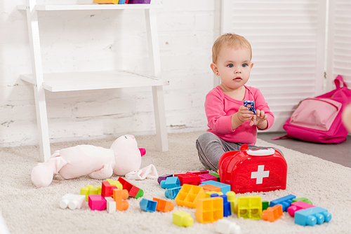 adorable kid playing with first aid kit in children room