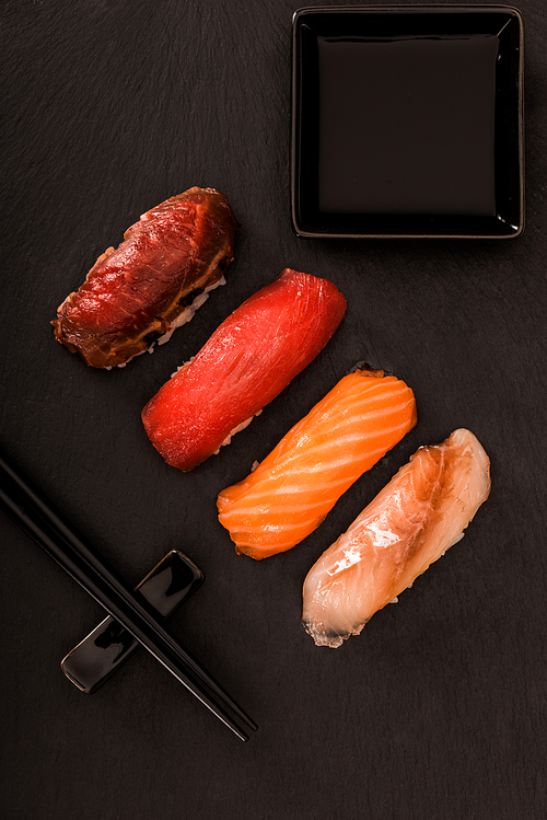 Top view of delicious sashimi sushi on black slate