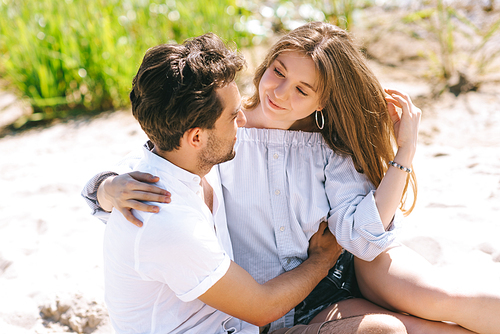 happy heterosexual couple hugging at sandy city beach