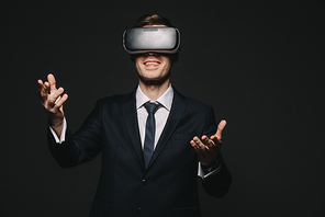 cheerful businessman in virtual reality headset isolated on black