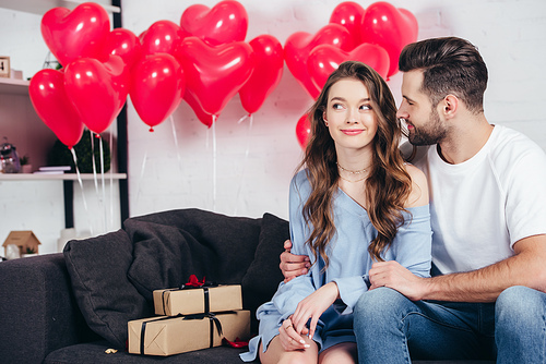 happy man looking at woman in room decorated for st valentine day