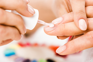 Partial shot of manicurist applying nail polish