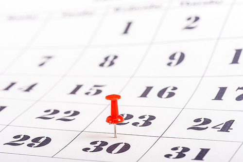 selective focus of red pin marking number 30 in calendar