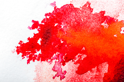 top view of red watercolor spill on white paper