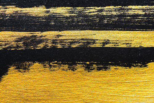top view of yellow watercolor brushstrokes on black background with copy space
