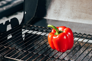 bright red fresh bell pepper on bbq grill grates