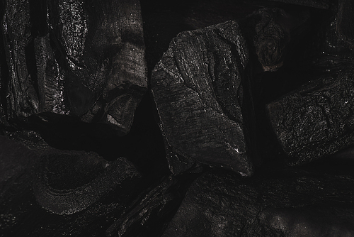 dark black background of textured charcoal with copy space