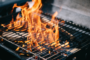 burning firewood with flame through bbq grill grates